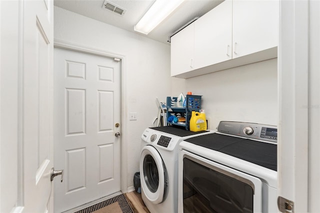 laundry room with cabinets, independent washer and dryer, and hardwood / wood-style floors