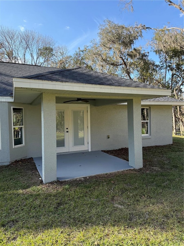 view of exterior entry with a patio area and a lawn