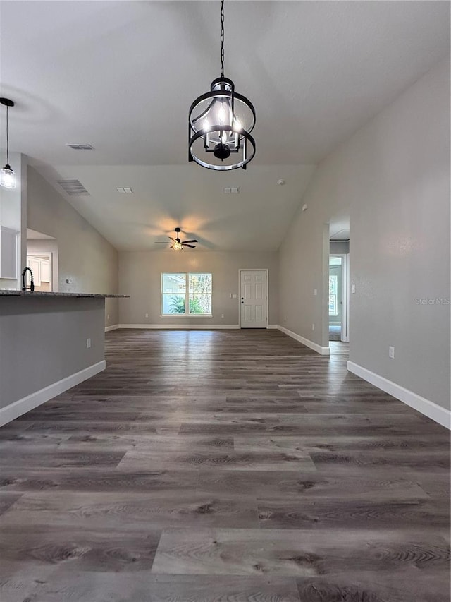 unfurnished living room featuring ceiling fan with notable chandelier, dark hardwood / wood-style floors, lofted ceiling, and sink