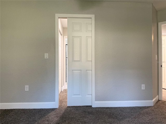 unfurnished bedroom with dark carpet