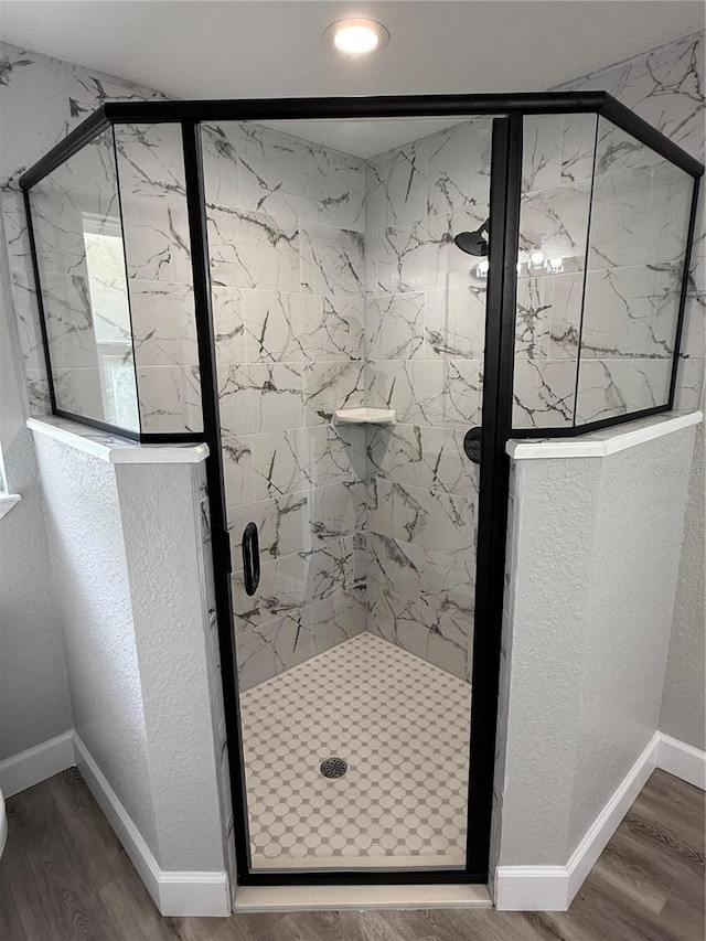 bathroom featuring a shower with shower door and hardwood / wood-style flooring