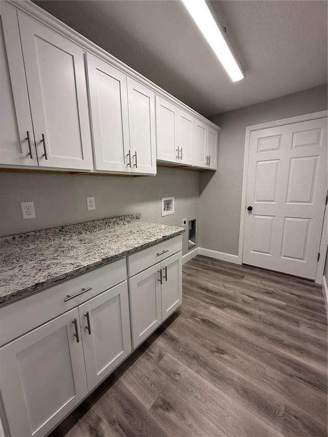 laundry room with dark wood-type flooring, cabinets, electric dryer hookup, hookup for a washing machine, and a textured ceiling