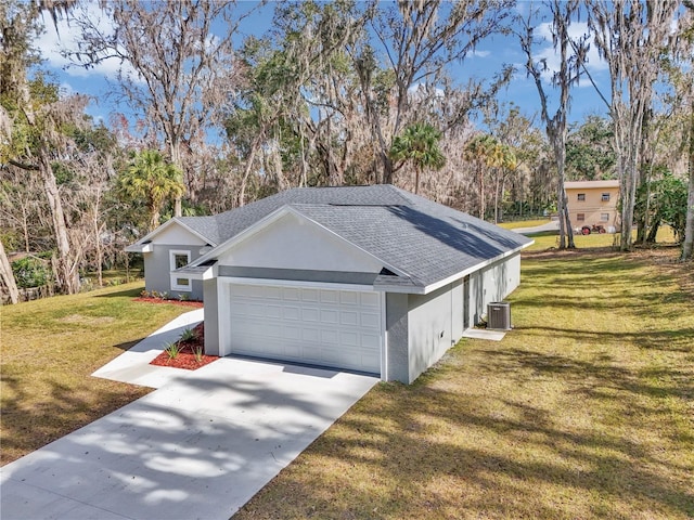 view of side of property with concrete driveway, a yard, an attached garage, and stucco siding