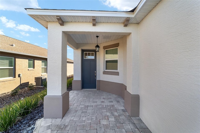 view of exterior entry featuring central AC unit