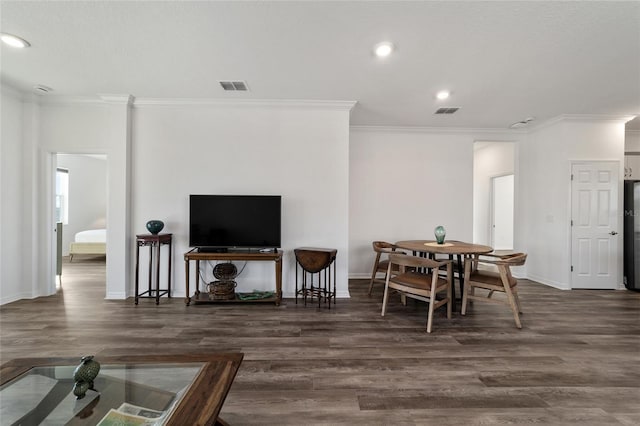 dining space featuring ornamental molding and dark wood-type flooring