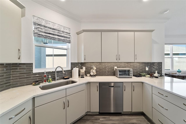 kitchen with decorative backsplash, light stone countertops, stainless steel dishwasher, crown molding, and sink