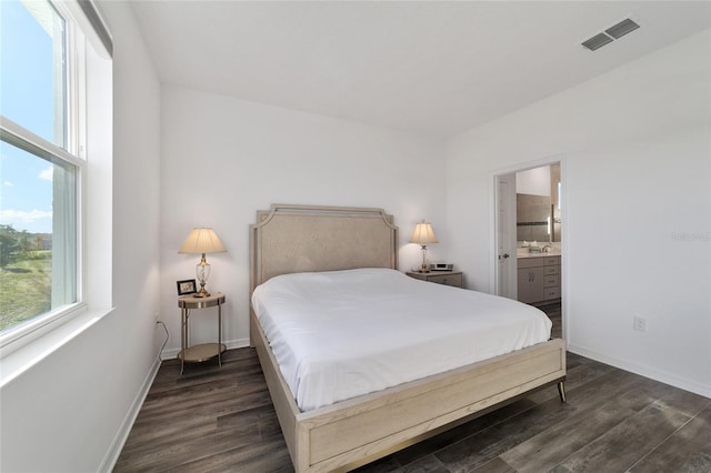 bedroom featuring ensuite bathroom and dark hardwood / wood-style floors