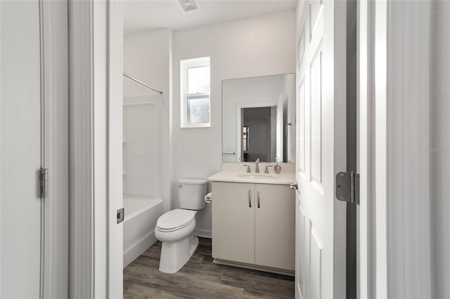 full bathroom with bathing tub / shower combination, hardwood / wood-style floors, vanity, and toilet