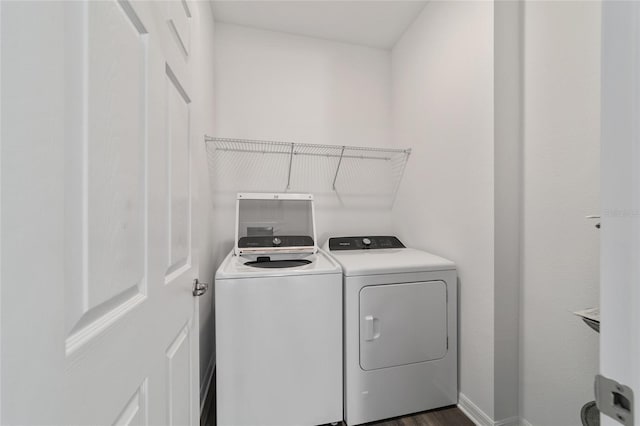 clothes washing area featuring separate washer and dryer and dark wood-type flooring