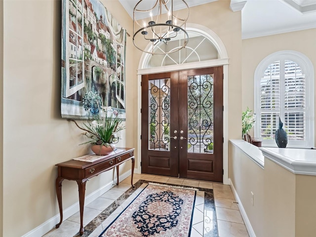 tiled entryway with a notable chandelier and french doors