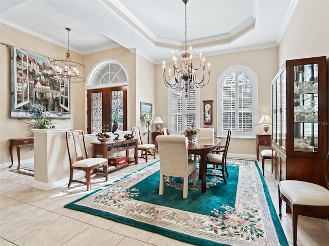 dining area with french doors, tile patterned floors, ornamental molding, a raised ceiling, and a notable chandelier