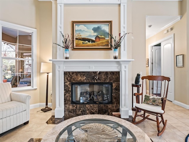 sitting room featuring a high end fireplace, light tile patterned flooring, and ornamental molding