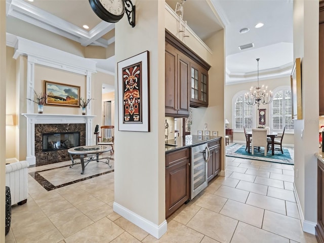 kitchen featuring a high end fireplace, light tile patterned floors, crown molding, and wine cooler