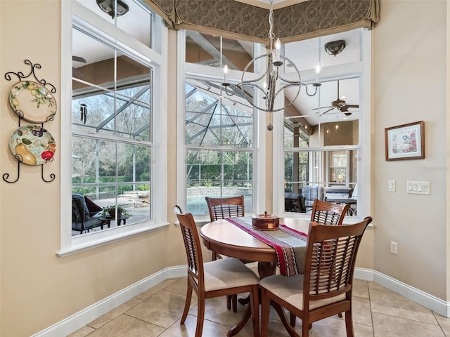 tiled dining space featuring a healthy amount of sunlight and ceiling fan with notable chandelier