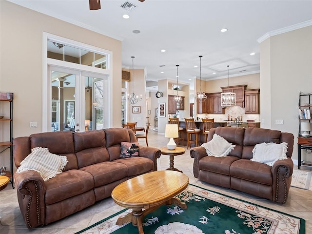 living room featuring light tile patterned floors, ceiling fan with notable chandelier, and ornamental molding