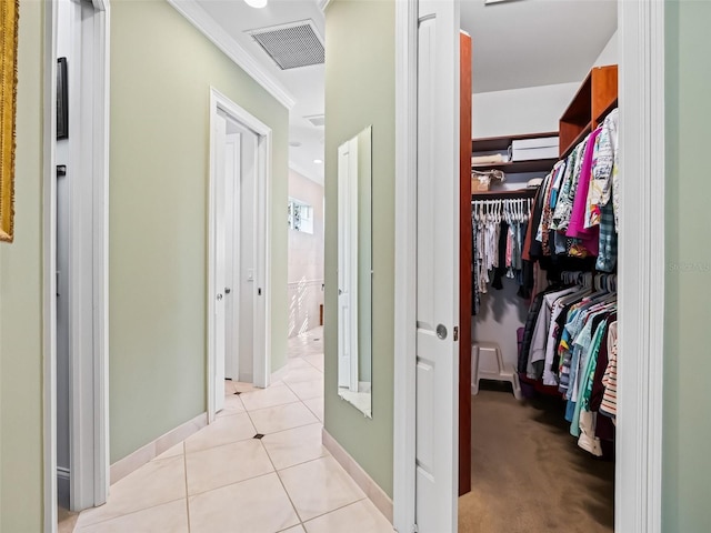 hallway with light tile patterned floors and ornamental molding