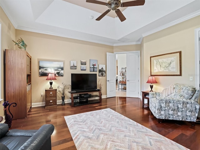 living room with crown molding, ceiling fan, a raised ceiling, and dark wood-type flooring