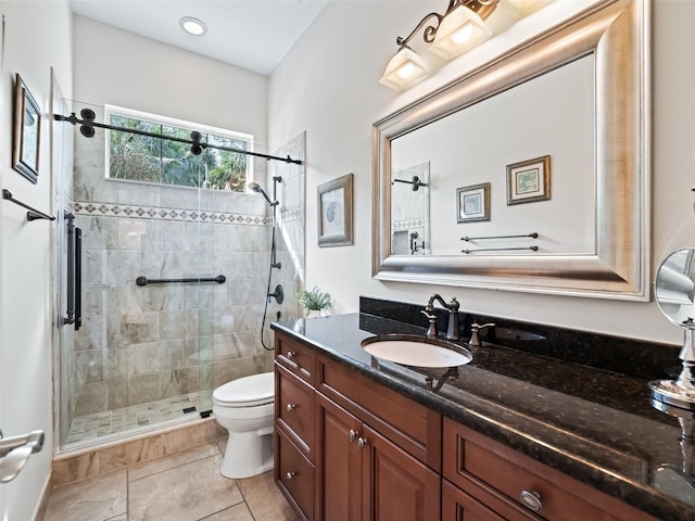 bathroom featuring tile patterned flooring, vanity, toilet, and walk in shower