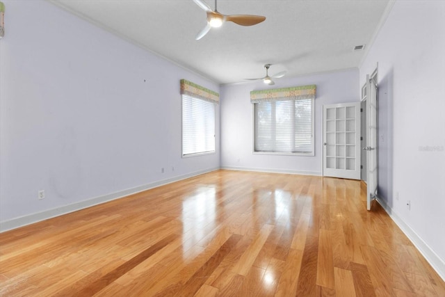 empty room featuring ceiling fan, light hardwood / wood-style floors, and crown molding