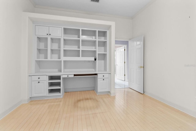 unfurnished office with light hardwood / wood-style flooring and crown molding