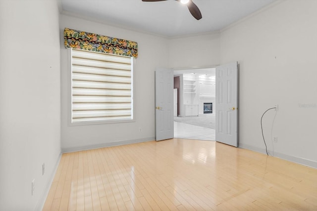 spare room with light hardwood / wood-style flooring, ceiling fan, and ornamental molding