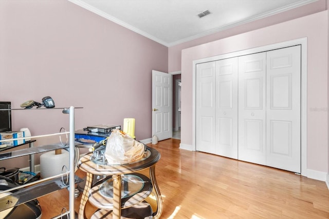 home office featuring light hardwood / wood-style flooring and crown molding