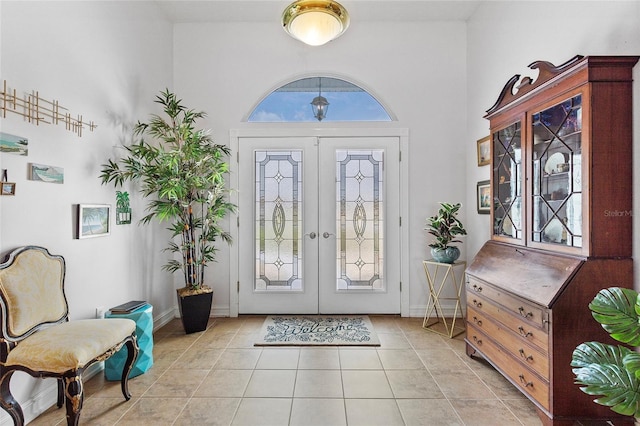 foyer with french doors, a wealth of natural light, and light tile patterned flooring