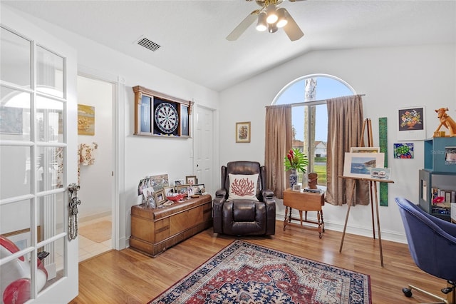 living area with ceiling fan, vaulted ceiling, and hardwood / wood-style flooring