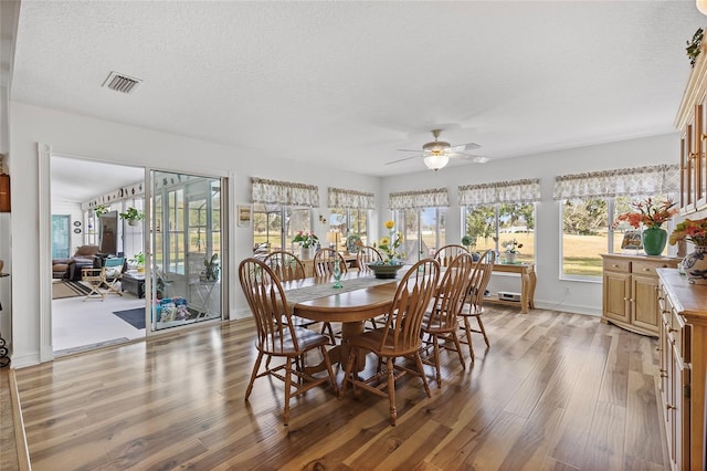 dining room with ceiling fan, light hardwood / wood-style floors, and a textured ceiling