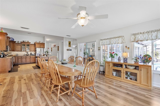 dining space with light hardwood / wood-style floors and ceiling fan