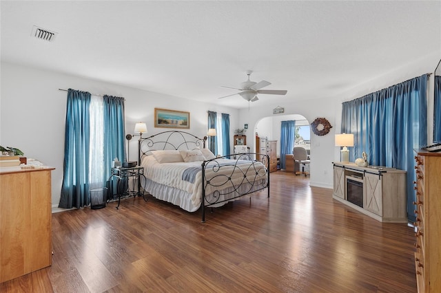 bedroom with ceiling fan, dark hardwood / wood-style floors, and multiple windows