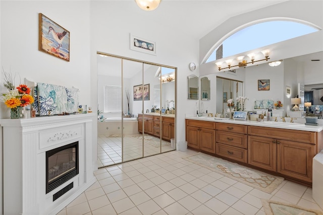 bathroom with tile patterned flooring, vanity, and lofted ceiling