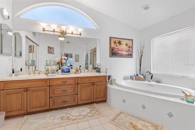 bathroom featuring tile patterned flooring, vanity, vaulted ceiling, and tiled tub