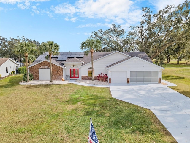 ranch-style house with solar panels, a garage, a front yard, and french doors