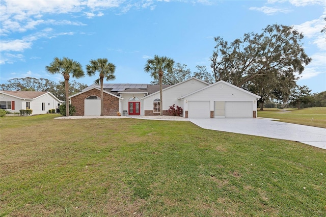 ranch-style home with a front lawn, a garage, and solar panels