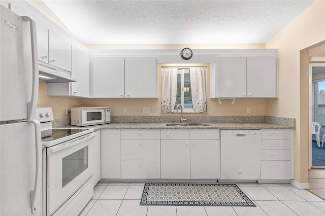 kitchen with sink, white cabinets, light tile patterned flooring, and white appliances