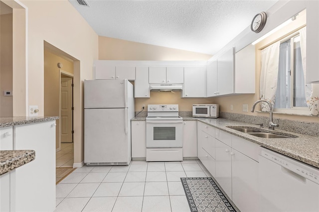 kitchen featuring white appliances, white cabinets, sink, vaulted ceiling, and light tile patterned floors