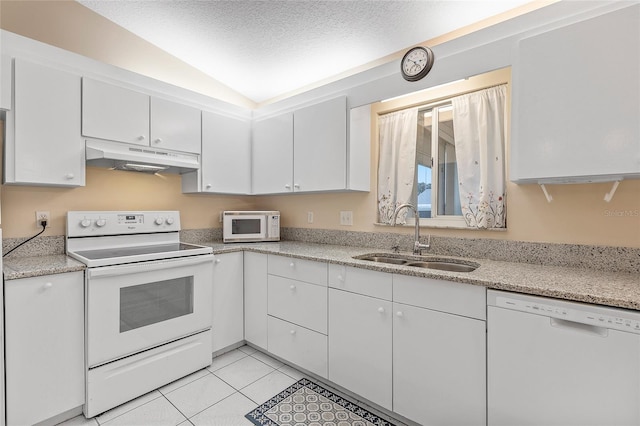 kitchen with sink, white cabinets, light tile patterned flooring, and white appliances