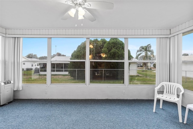 unfurnished sunroom featuring ceiling fan and a healthy amount of sunlight