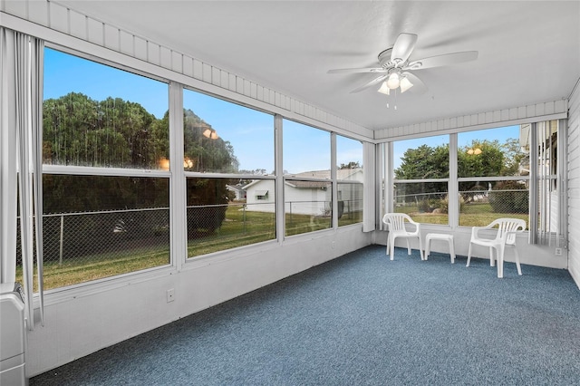 unfurnished sunroom with ceiling fan