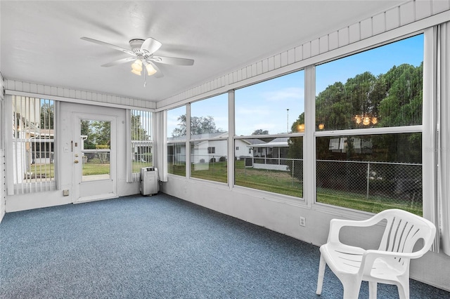 unfurnished sunroom featuring ceiling fan and plenty of natural light