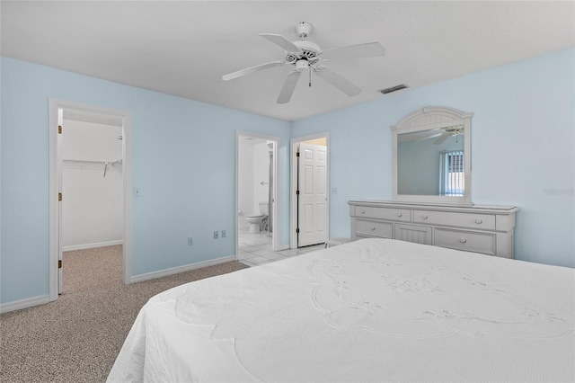 carpeted bedroom with ceiling fan, a walk in closet, connected bathroom, and a closet