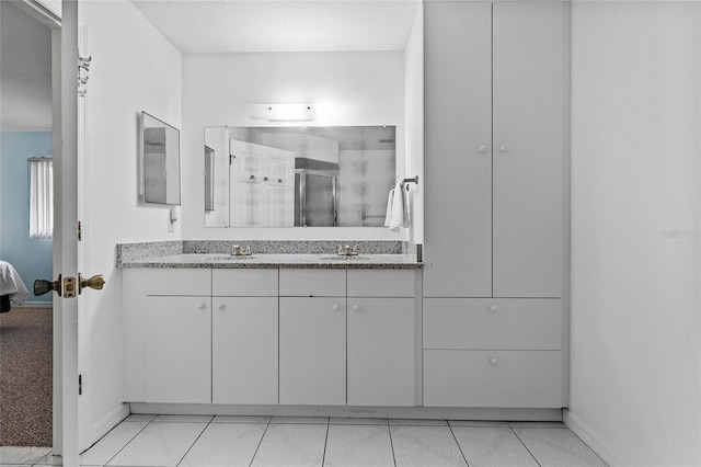 bathroom featuring a textured ceiling, vanity, tile patterned floors, and walk in shower