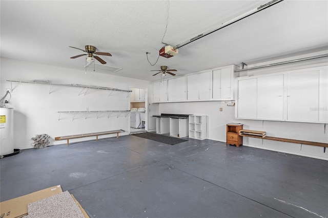 garage with washing machine and dryer, a garage door opener, ceiling fan, and water heater