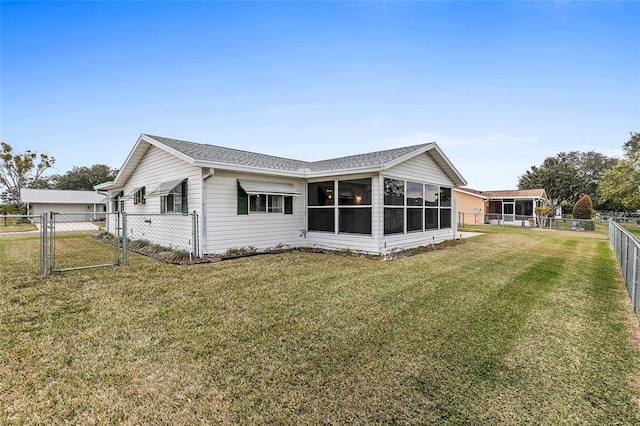 back of property with a sunroom and a yard