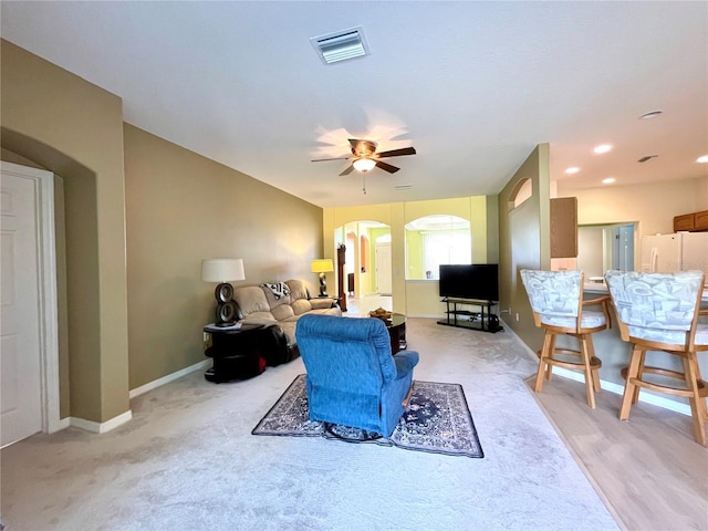 carpeted living room with ceiling fan