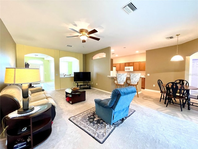 carpeted living room with ceiling fan