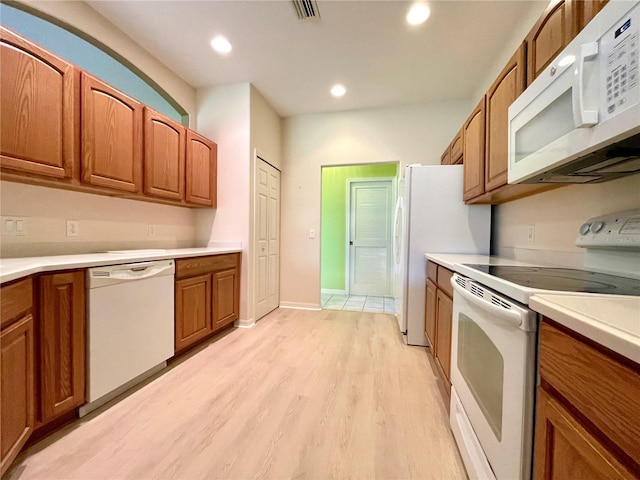 kitchen with light hardwood / wood-style flooring and white appliances