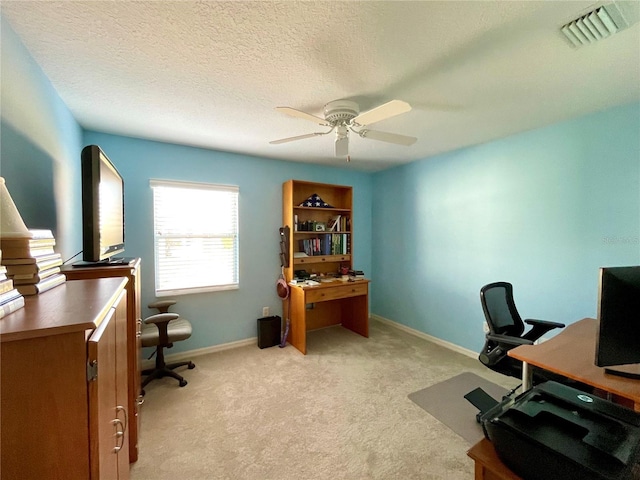 carpeted office with ceiling fan and a textured ceiling