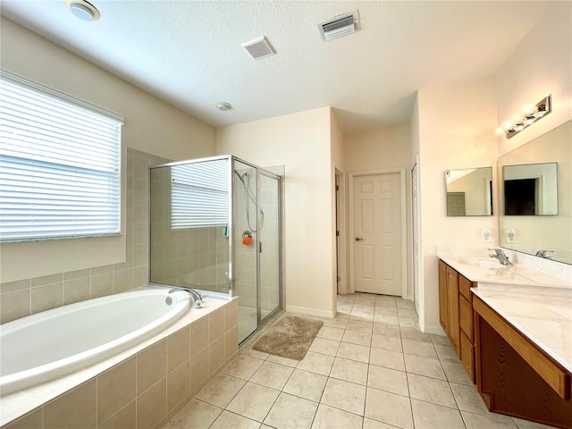 bathroom featuring tile patterned flooring, vanity, a textured ceiling, and independent shower and bath